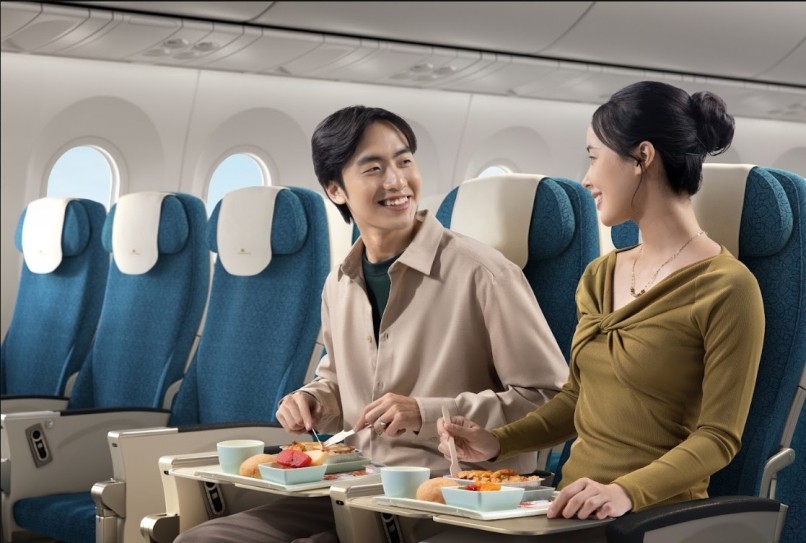 Two passengers enjoying a hot meal in Vietnam Airlines Economy Class