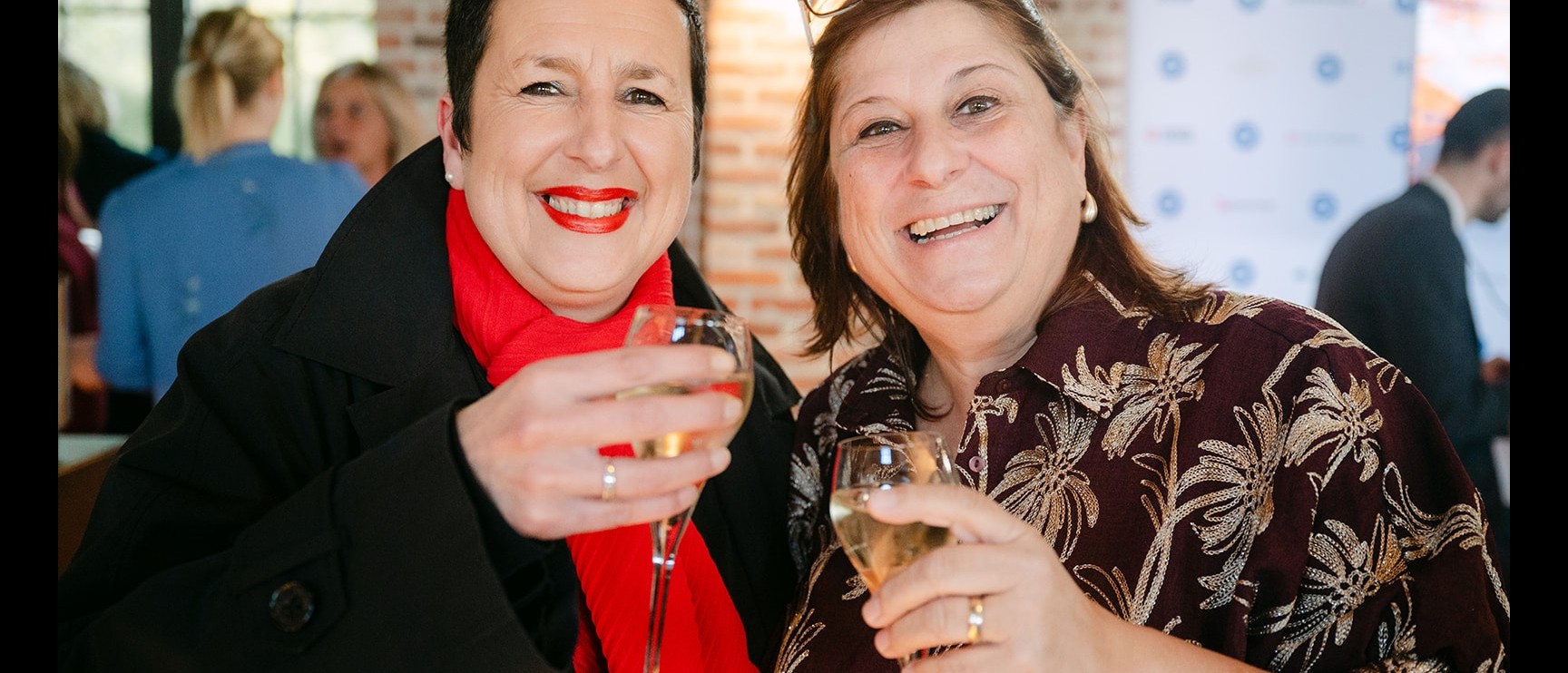 Twee gasten proosten met een glas champagne tijdens de receptie