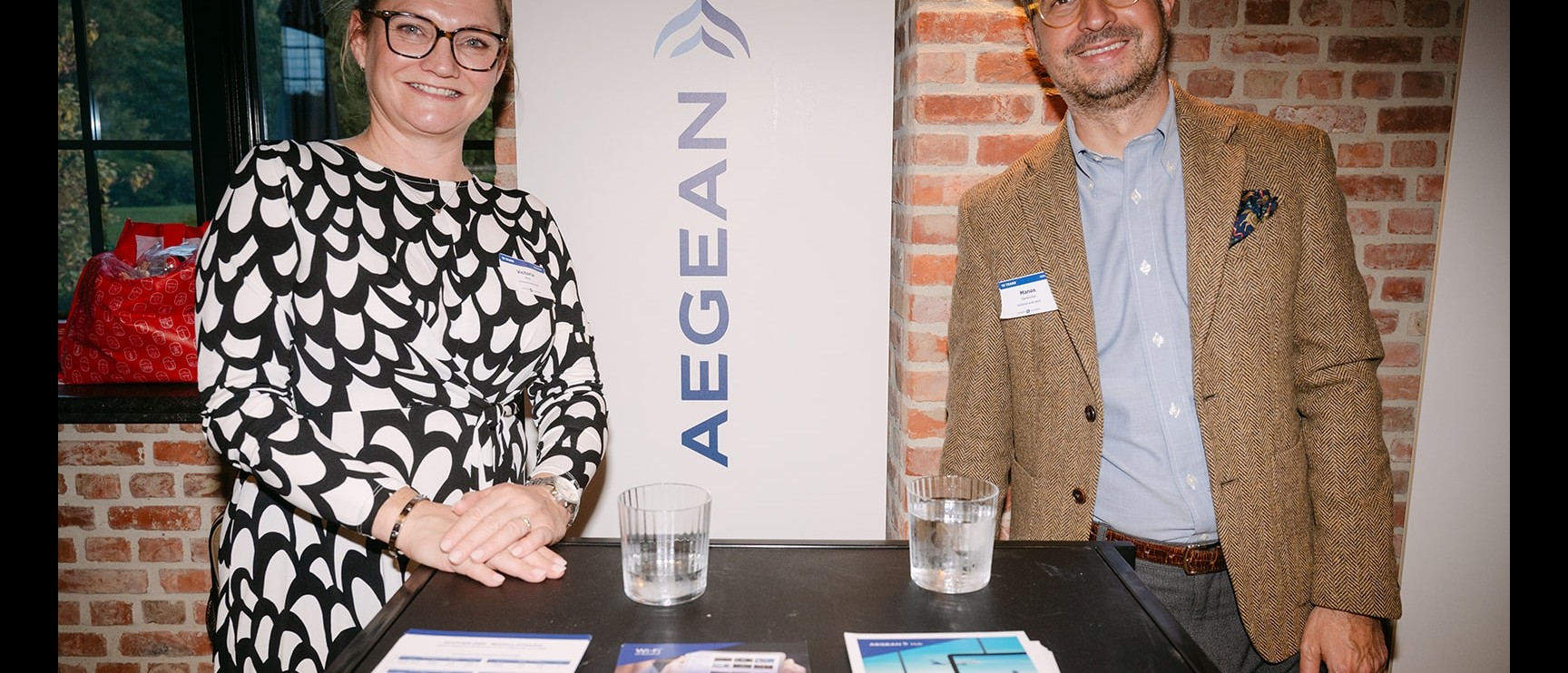 Twee vertegenwoordigers van Aegean aan hun tafel tijdens 10 jaar Getflights